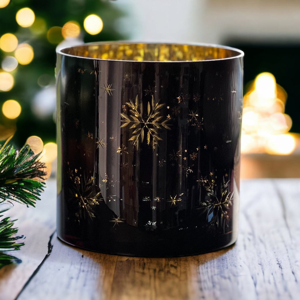 festive candle holders, adorned with snowflakes in varying sizes. Their glossy dark blue-black exterior finish paired with a shiny golden interior layer creates a mesmerising effect,